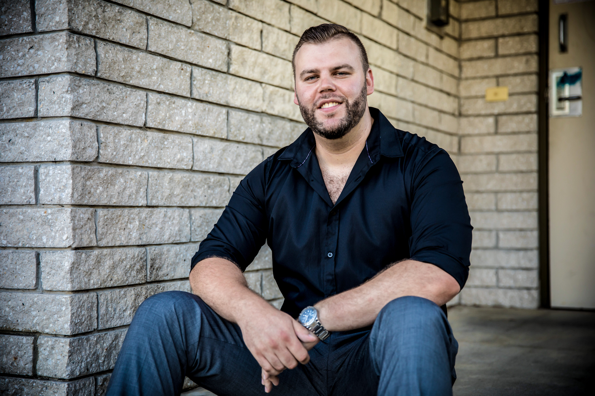 Martin sitting against a brick wall
